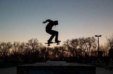 AI generated illustration of a skateboarder jumps over ramp at sunset
