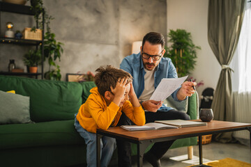 exhausted father help son to finish his homework © Miljan Živković