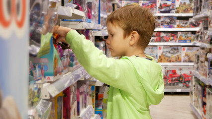 A cute boy choosing a toy in a toy store