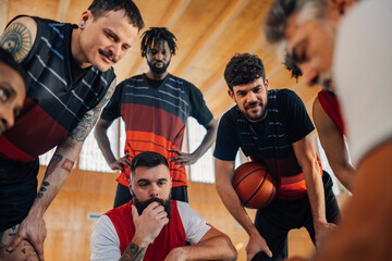 Portrait of a diverse basketball team having a team talk with their coach