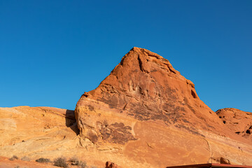 Panoramic sunrise view of one of group of seven tall, red, Aztec Sandstone Rock eroded boulders called Seven Sisters in Valley of Fire State Park in Mojave desert near Overton, Nevada, USA. Road trip