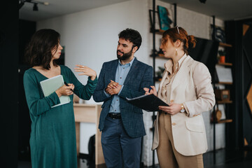 Three creative industry experts share ideas and converse in a collaborative meeting environment, showcasing teamwork and innovation.