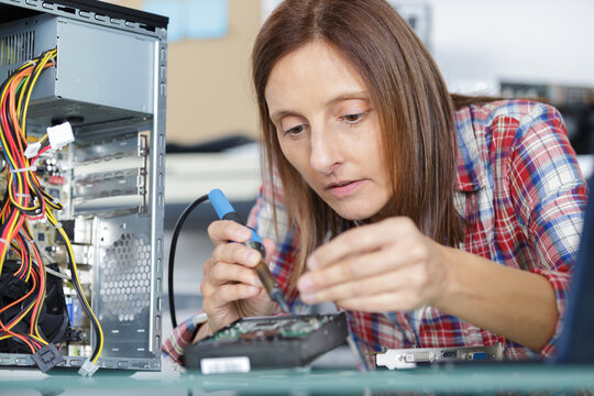 female computer technician using a soldering iron