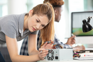 young woman technician repairing computer - obrazy, fototapety, plakaty