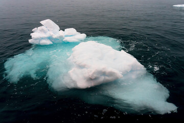 floating iceberg partially submerged with aqua ice in Greenland
