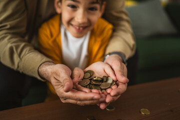 Close up hands of father and son hold coins money