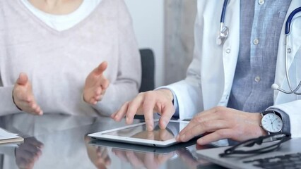 Doctor and patient conversation with tablet computer in clinic office. Medicine and Health care