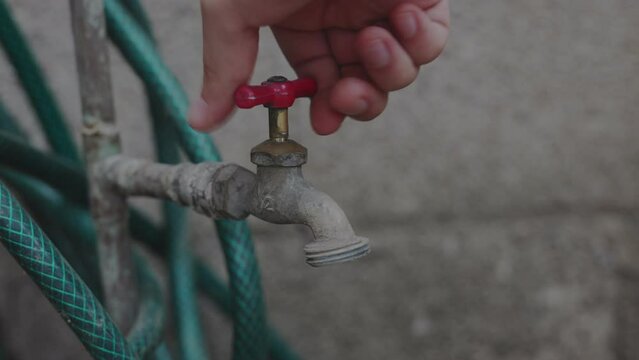 Hand of a person turning on the water faucet without water during a shortage. water crisis concept