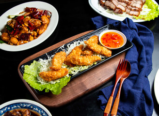 Crispy fish fillet with chilli sauce spoon and fork served in dish isolated on wooden board side view of taiwan food