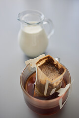 barista pouring hot water on rough brown bubbles coffee through drip filter, home brewing process