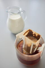 barista pouring hot water on rough brown bubbles coffee through drip filter, home brewing process