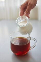 Pouring Cream into a Cup of Coffee