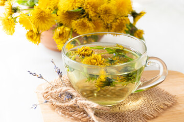 Yellow dandelion flowers and dandelion tea cup