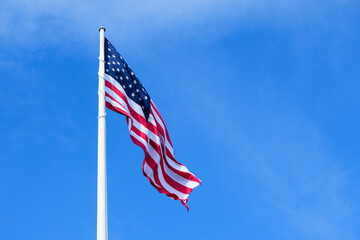 large american flag waving against blue sky, patriot and independence holidays