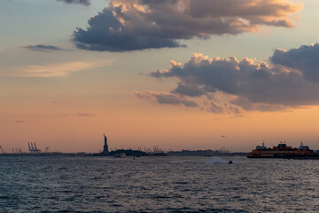 A distant view on Statue of Liberty from Battery Park. There are a lot of factories over the...
