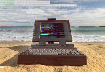 laptop computer system by the sea with code and data on screen
