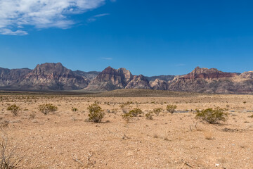 Barren landscape with view of limestone peaks Mount Wilson, Bridge and Rainbow Mountain of Red Rock Canyon National Conservation Area in Mojave Desert, Las Vegas, Nevada, United States. Remote hiking