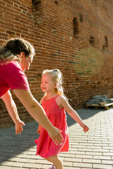 Child girl with cochlear implant with her mother spend time outdoor. Hear impairment and deaf...