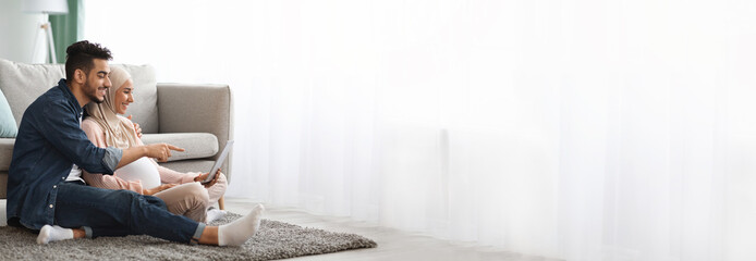 Couple relaxed and browsing on a tablet