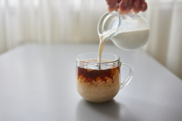 Pouring Cream into a Cup of Coffee