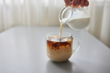 Pouring Cream into a Cup of Coffee