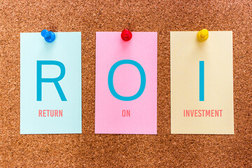 Conceptual 3 letters keyword ROI (Return On Investment), on multicolored stickers attached to a...