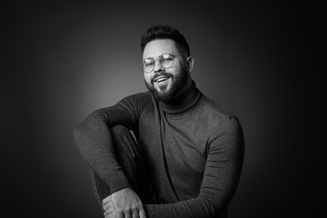 Portrait of handsome bearded man on dark background. Black and white effect