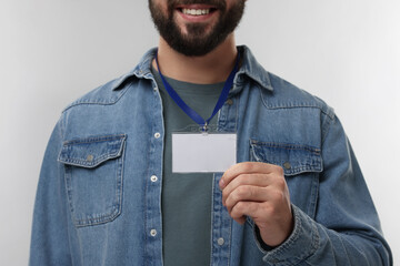 Man with blank badge on grey background, closeup