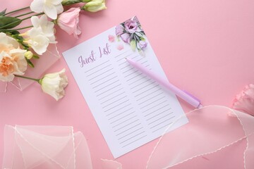 Guest list, pen, tulle fabric and beautiful flowers on pink background, flat lay. Space for text