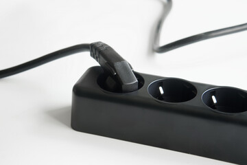 Heavy-duty, thick-wire, electrical extension cord, with three outlets and an attached electrical...