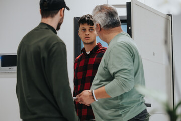 An intense discussion among three men, dressed casually, unfolded in a contemporary office environment, highlighting collaboration and communication.