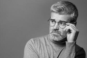 Fototapeta premium Portrait of handsome man on grey background, space for text. Black and white effect