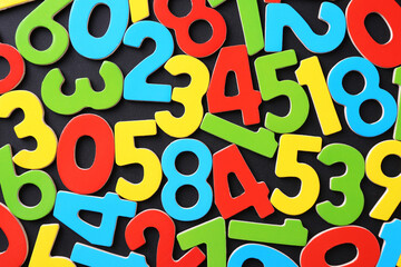 Colorful numbers on black background, top view