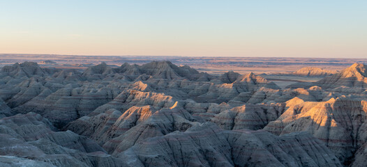 Panoramic Views of the golden rays of sun touching the cliffs and canyons of South Dakota's...