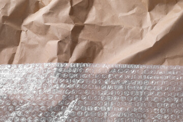 Transparent bubble wrap on kraft paper, top view. Space for text