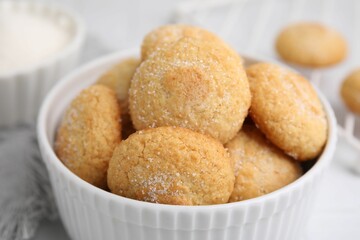 Tasty sugar cookies in bowl on white table, closeup