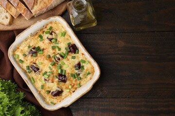 Tasty sausage casserole with green onions in baking dish on wooden table, flat lay. Space for text