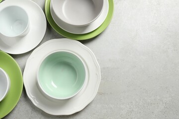 Beautiful ceramic dishware on light grey table, flat lay. Space for text