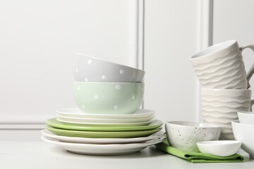 Beautiful ceramic dishware and cups on white table