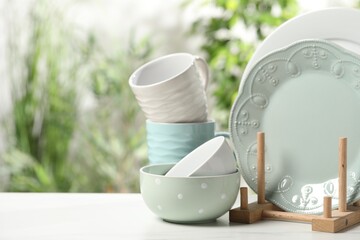 Beautiful ceramic dishware and cup on white table outdoors, space for text