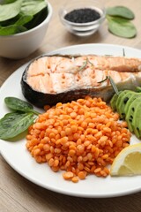 Plate with healthy food high in vegetable fats on wooden table, closeup