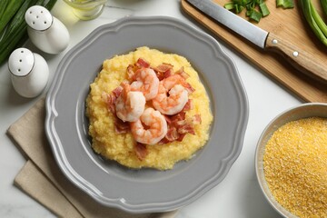 Plate with fresh tasty shrimps, bacon, grits and green onion on white marble table, flat lay