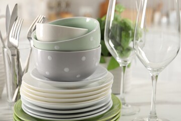 Many different clean dishware, glasses and cutlery on table indoors, closeup