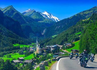 Heiligenblut village and church in Austria Alps with motorcycles driving on road