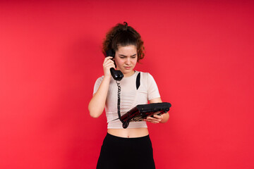Portrait of pretty person arms hold vintage handset doubtful face isolated on red color background