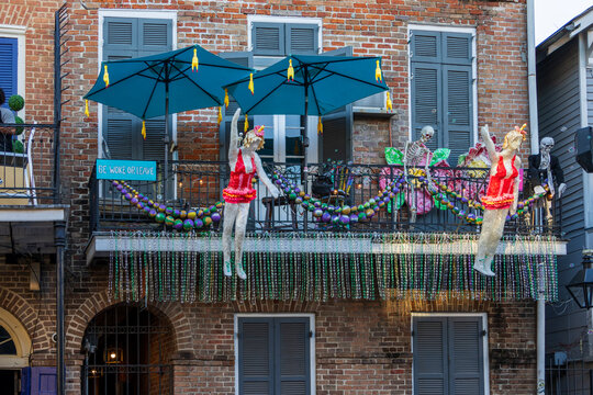 Mardi Gras decorations with beads and blow up dolls on a balcony of a red brick building on Bourbon Street in the French Quarters in New Orleans Louisiana USA