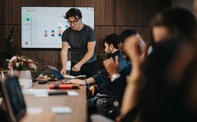 Intense discussion among business colleagues in a modern office. Team analyzing data, graphs, and business growth on a presentation screen.