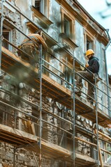 Fototapeta premium A skilled construction worker focused on the restoration of an old building, secured with the scaffolding