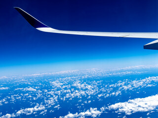 Wing of an airplane seen from the window flying over the Atlantic Ocean, on a vacation trip to the...