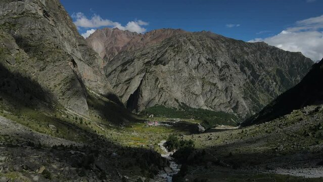 Aerial Drone shot of a small village covered by huge mountains of Himalayas.